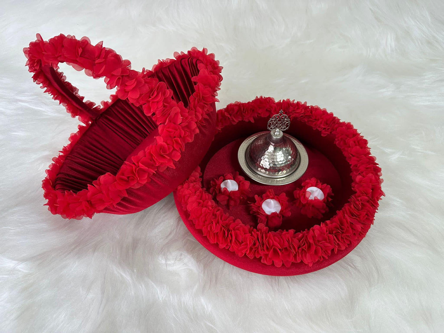 A henna basket with floral accents and henna tray with floral accents, there are three white led candles and henna silver iron dome inside tray