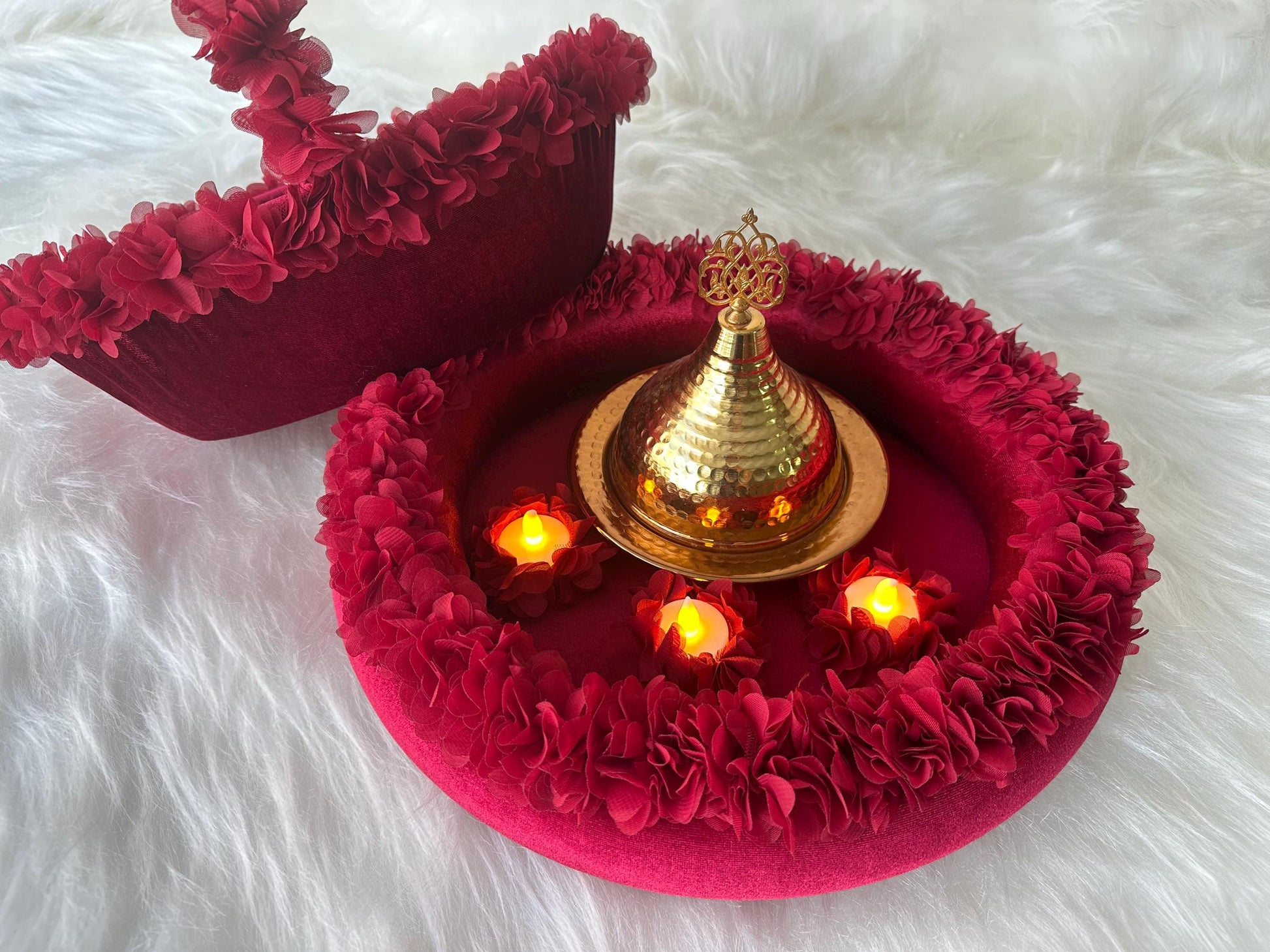 A henna basket with floral accents and henna tray with floral accents, there are three yellow led candles and henna golden iron dome inside tray