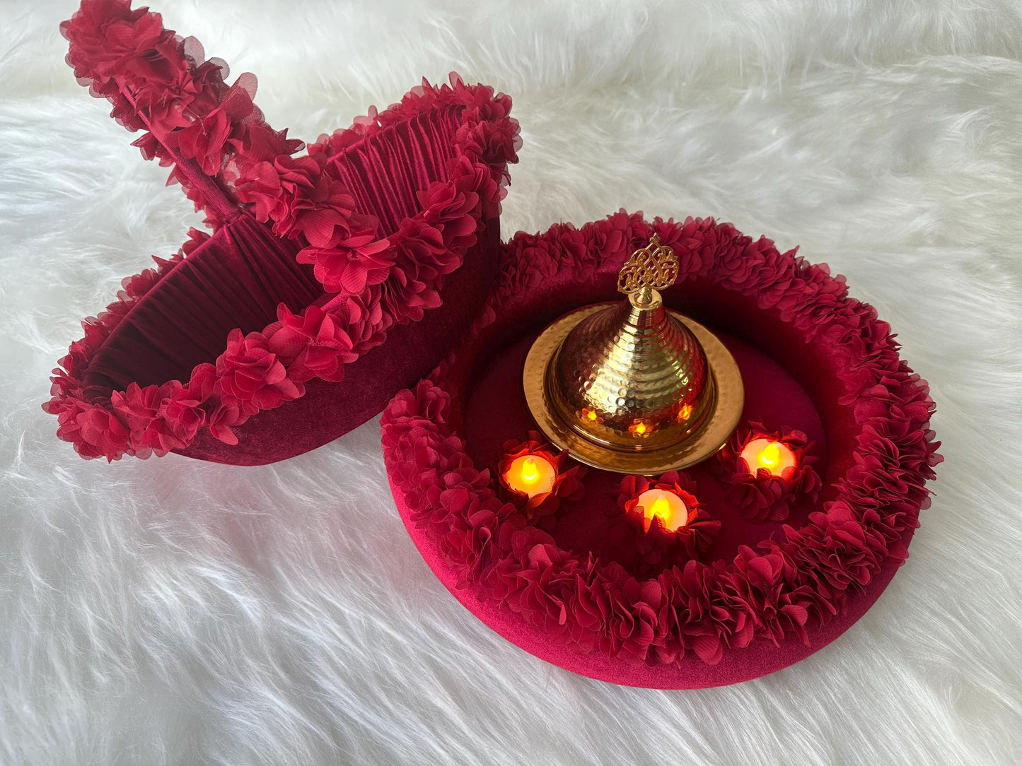 A henna basket with floral accents and henna tray with floral accents, there are three yellow led candles and henna golden iron dome inside tray