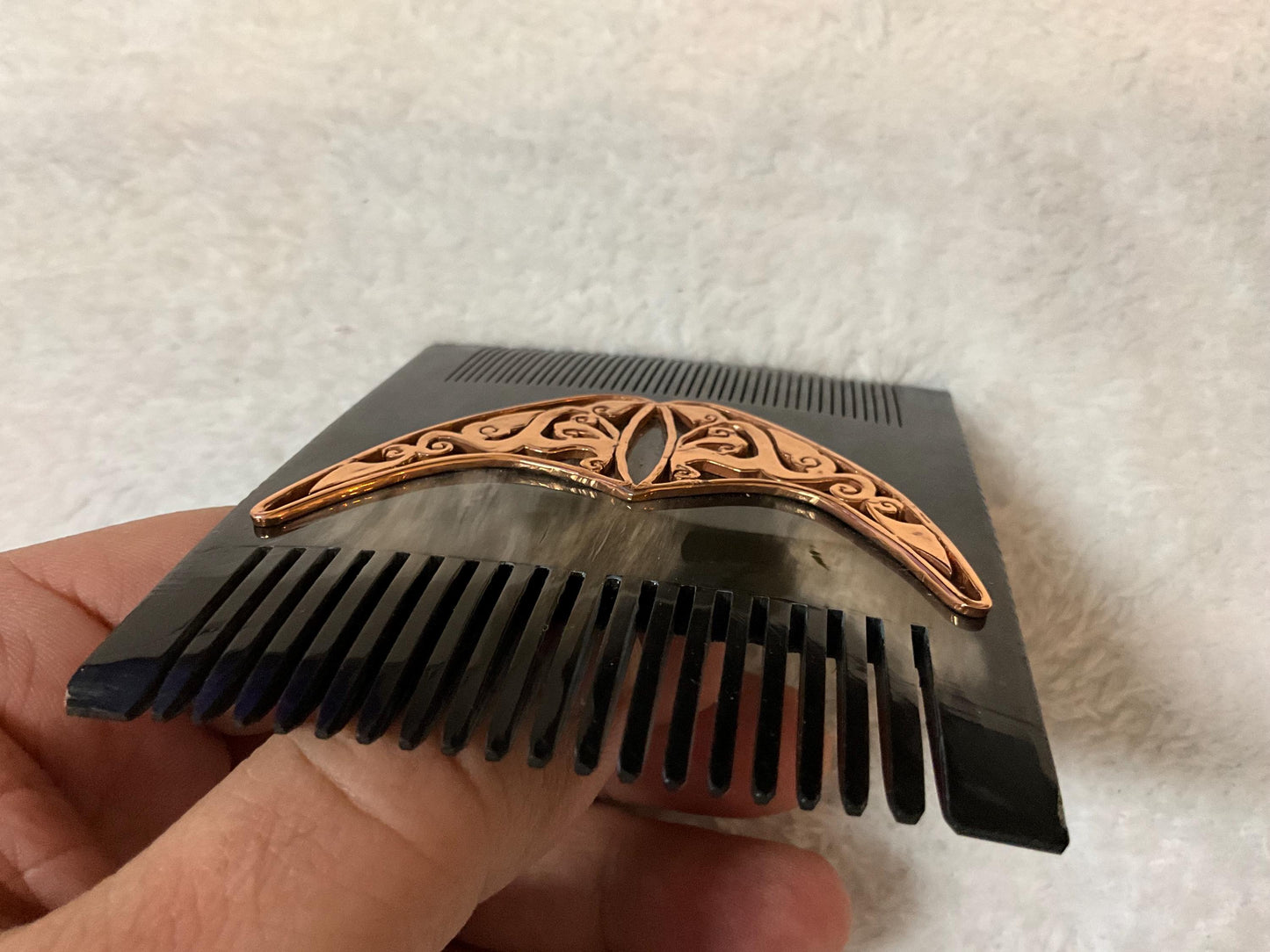 Natural black comb from upper side. It is over white carpet and it is seem as same size as a man.