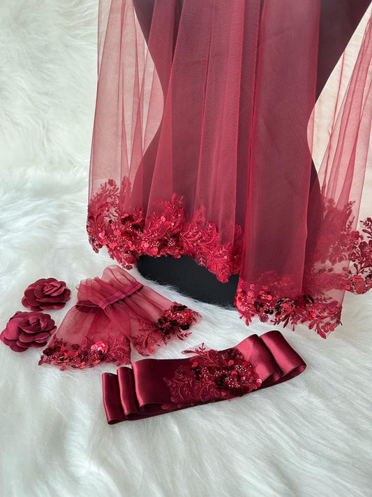 A burgundy bridal veil with lace and sequins, a matching burgundy sash with lace and sequins, and two burgundy floral hair clips.