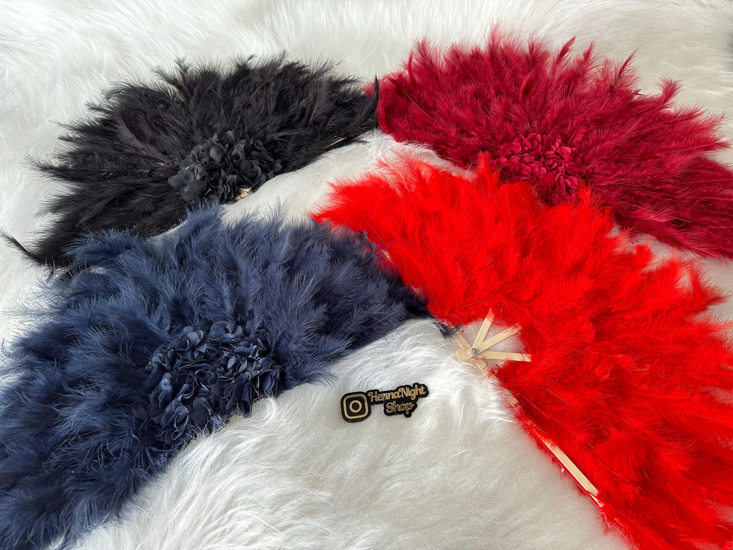 4 pieces henna feather fan. They are red, blue, black, burgundy over white carpet